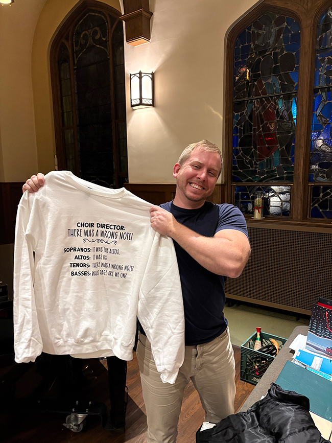 Ross Jallo holding a gift from the choir